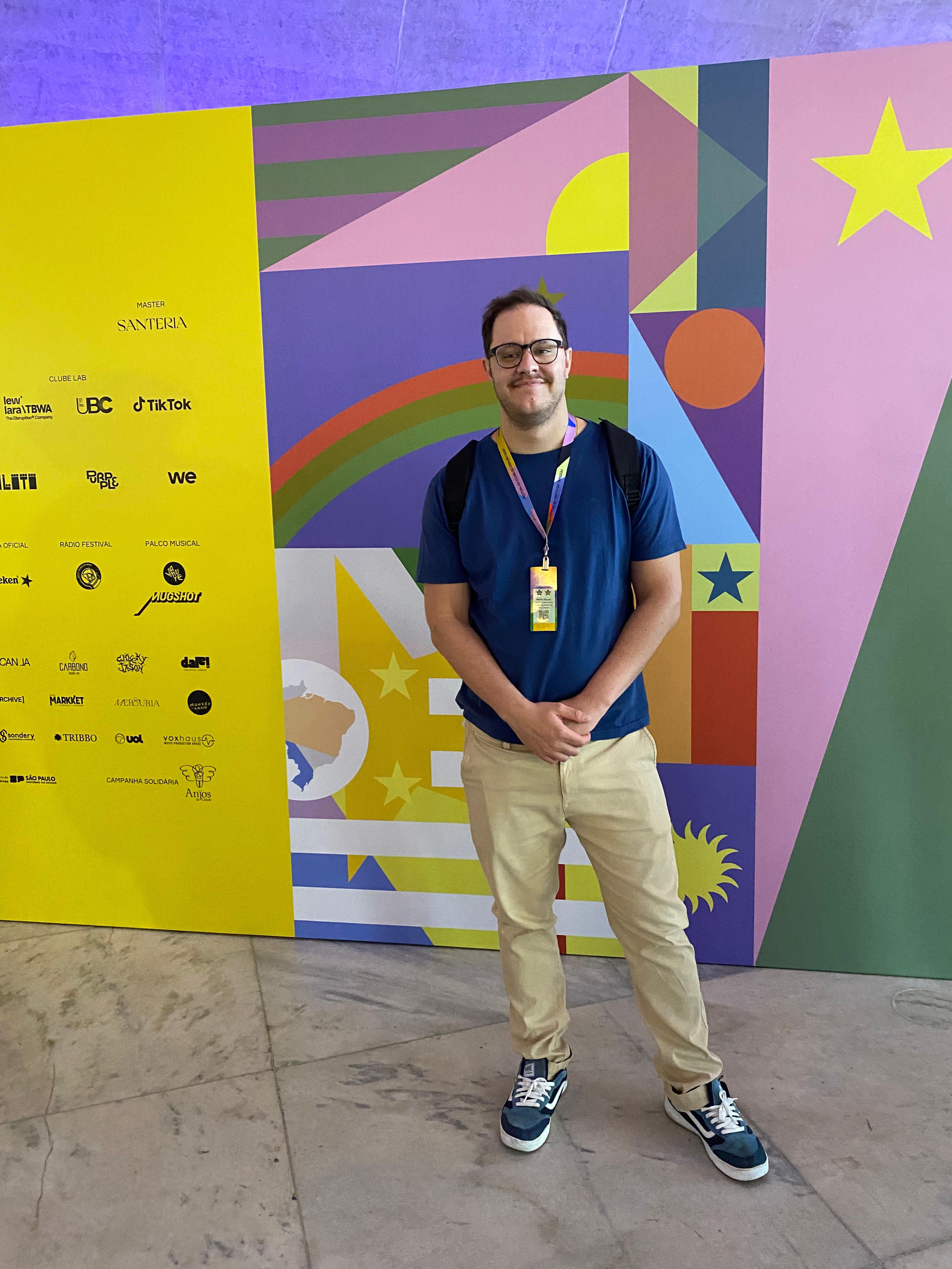 Murilo Souza em um painel colorido.